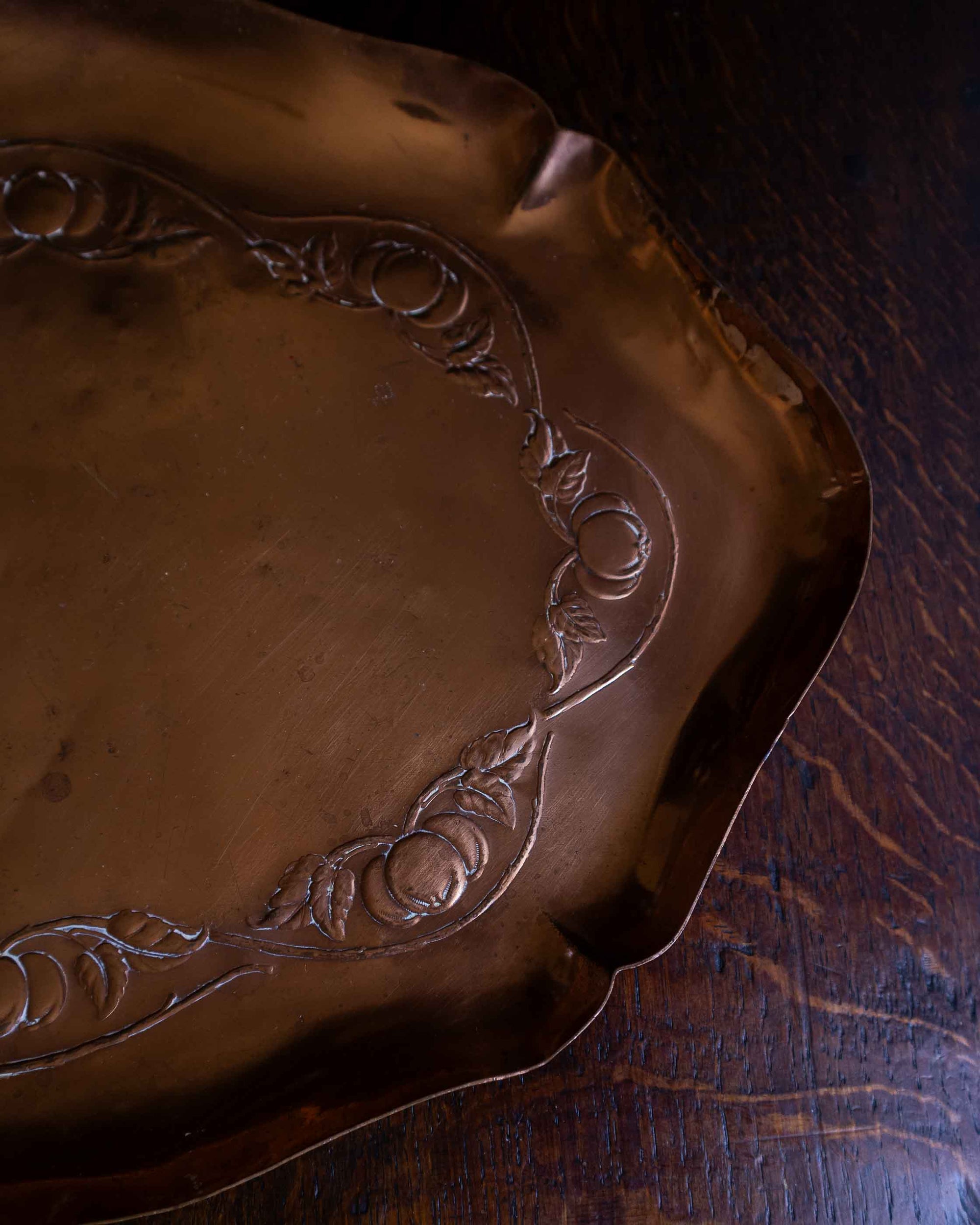 Decorative copper tray on a wooden surface