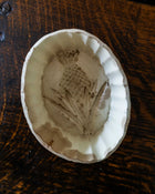 Decorative ceramic mould with pineapple design on a wooden surface