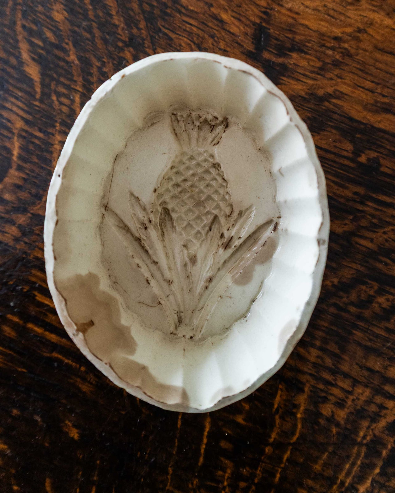 Decorative ceramic mould with pineapple design on a wooden surface