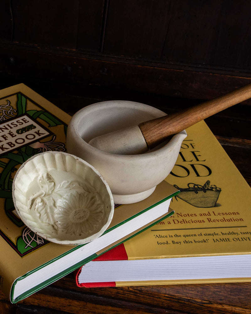 Mortar and pestle on a book with a decorative mould