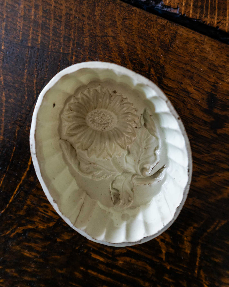 Decorative ceramic mould with floral design on a wooden surface