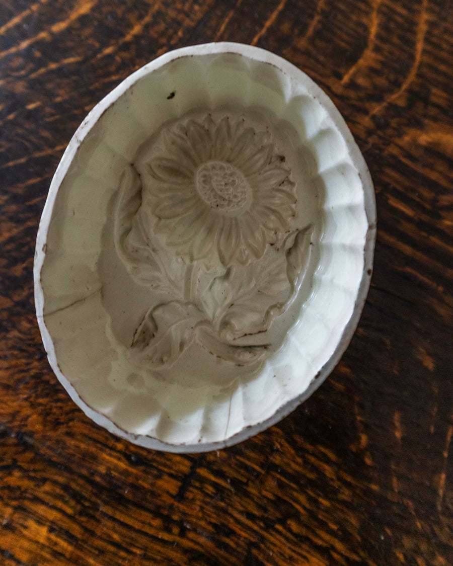Decorative ceramic mould with floral design on a wooden surface