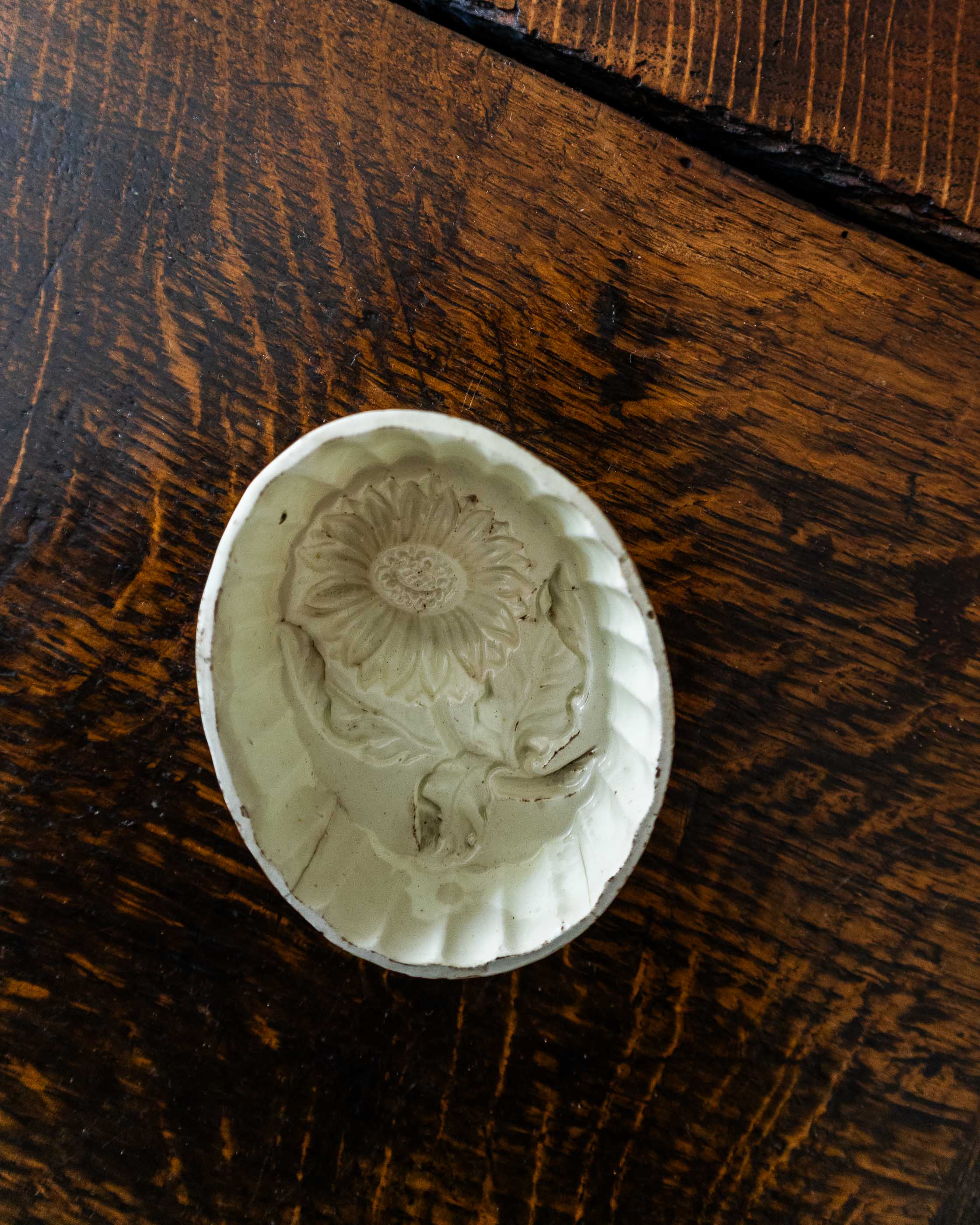 Decorative ceramic mould with floral design on a wooden surface
