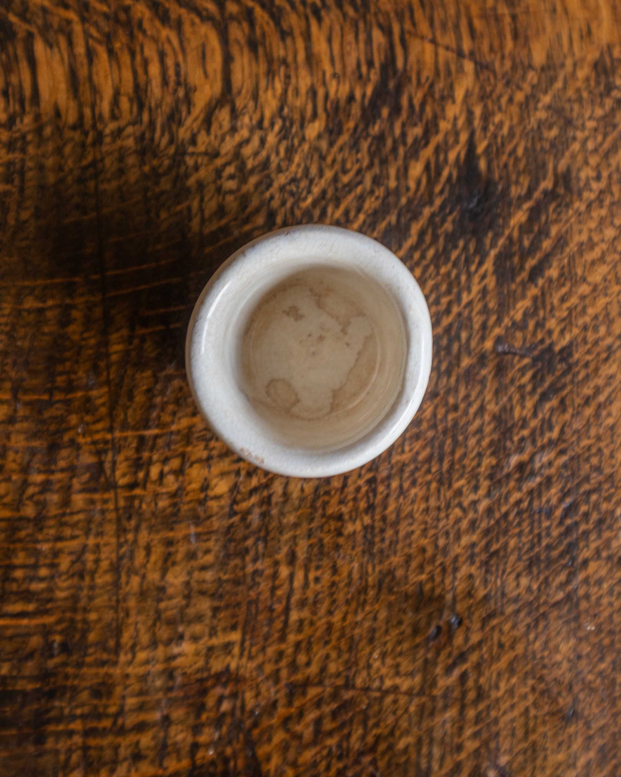 Small white ceramic pot on a wooden surface