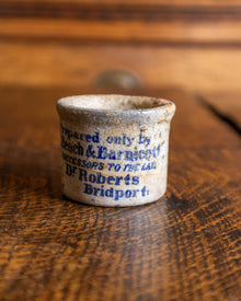 Ceramic pot with text on a wooden surface