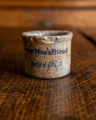 Ceramic pot with text on a wooden surface