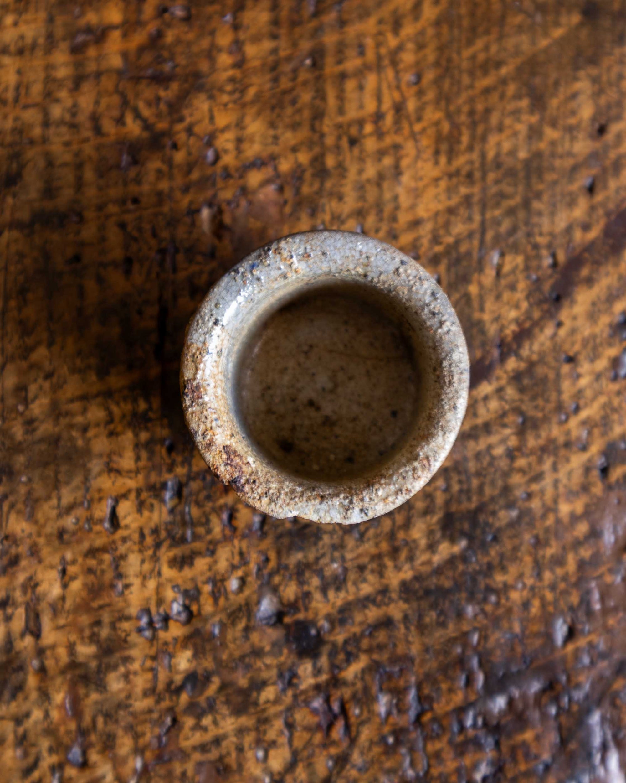 Small ceramic pot on a textured wooden surface
