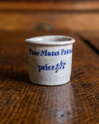 Small ceramic pot with text on a wooden surface