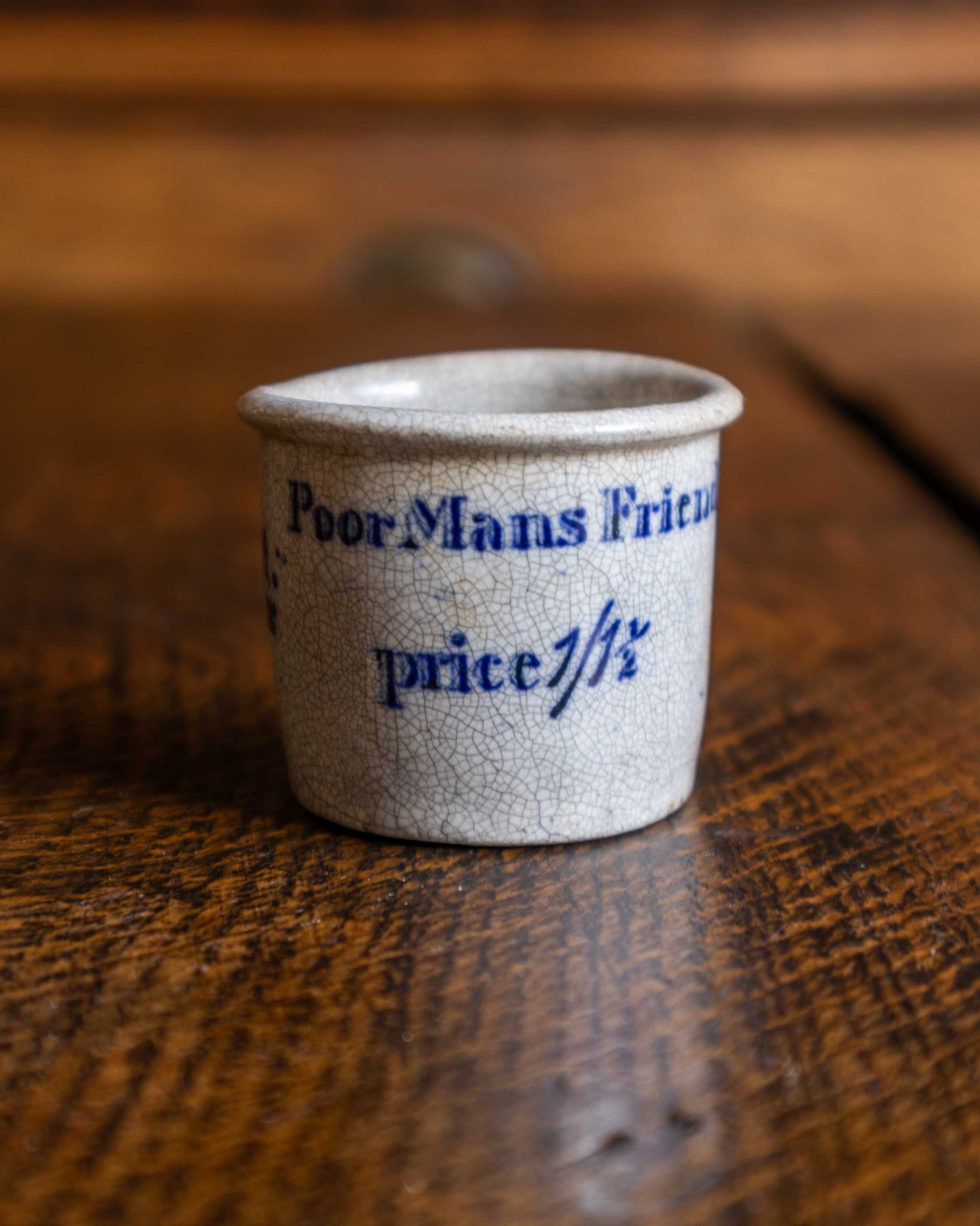 Small ceramic pot with text on a wooden surface