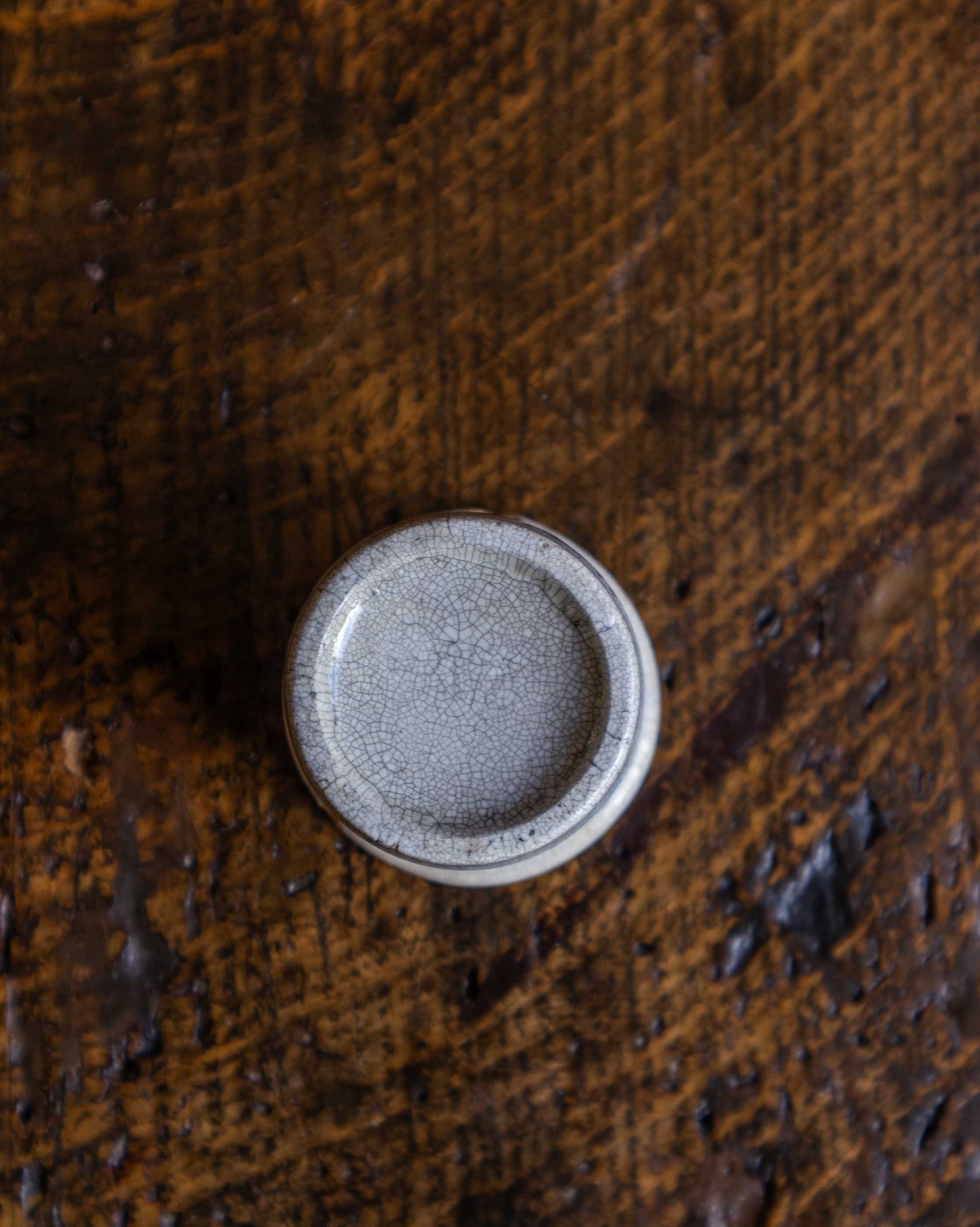 Round ceramic pot on a textured brown surface