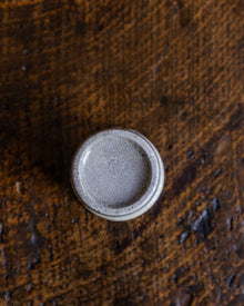 Round ceramic pot on a textured brown surface