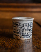 Small ceramic pot with design on a wooden surface