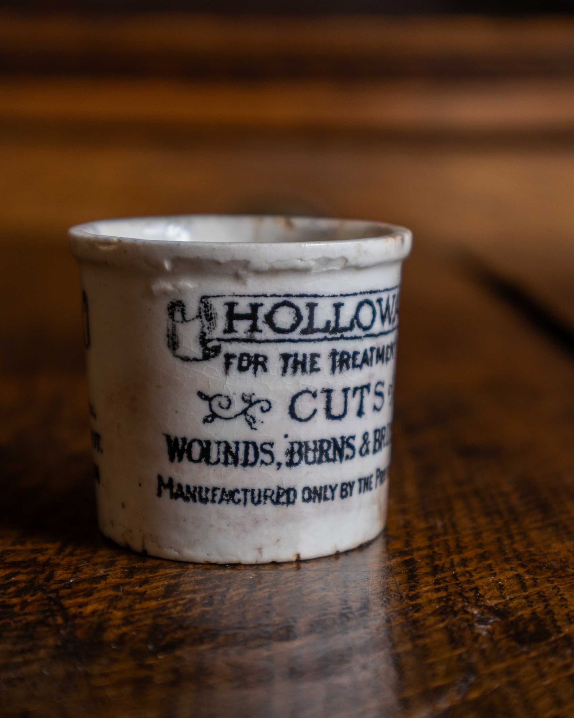 Small ceramic pot with text on a wooden surface