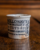 Ceramic pot with text on a wooden surface