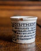 Ceramic pot with text on a wooden surface