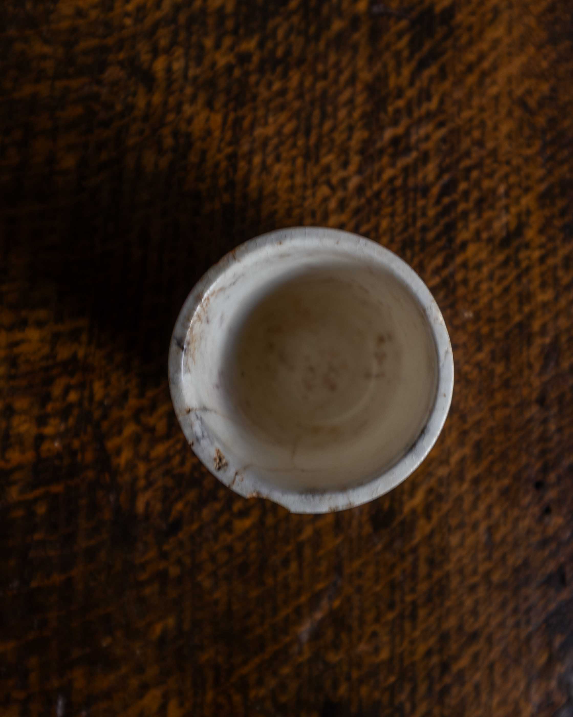 White ceramic pot on a textured brown surface