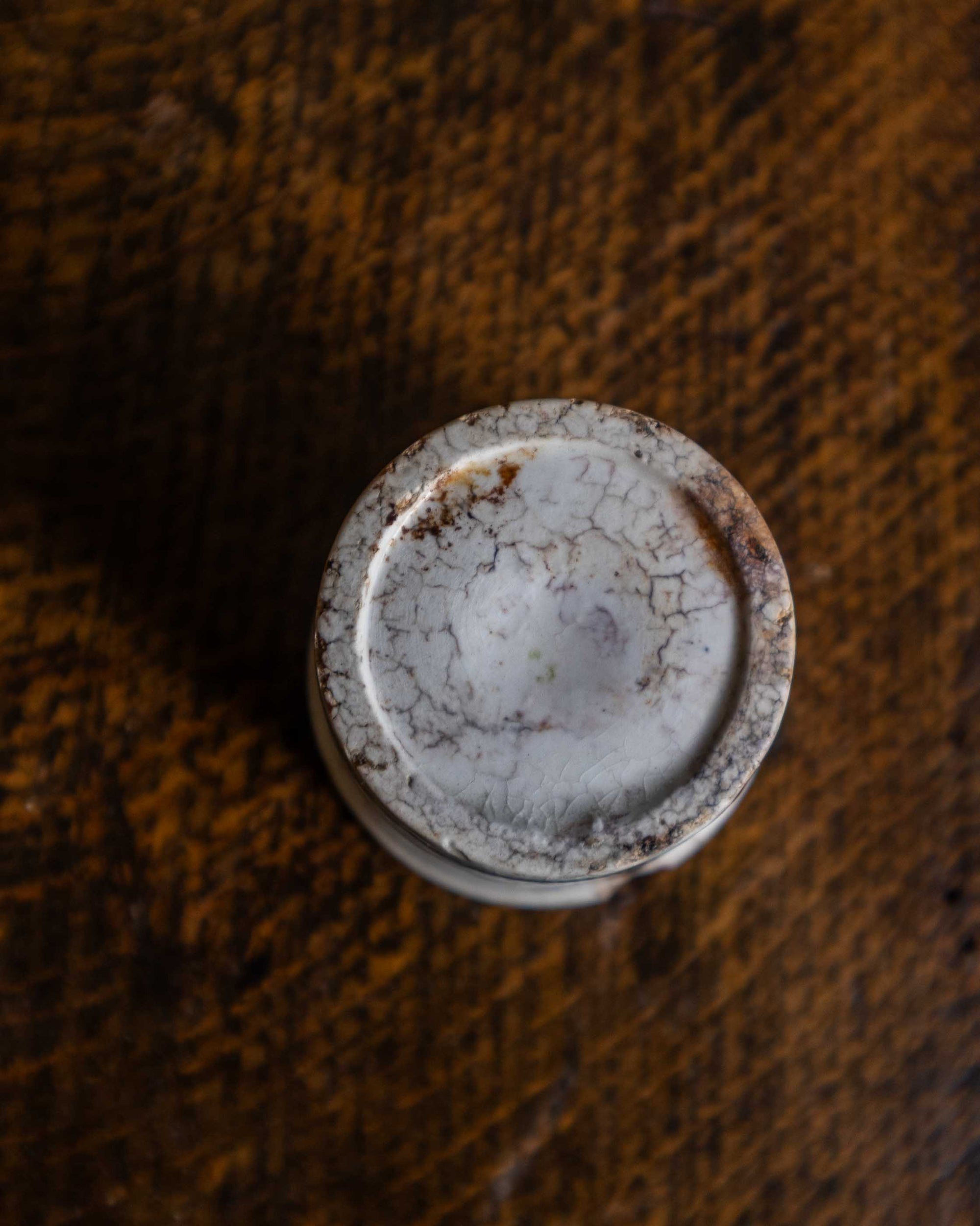 White ceramic pot on a textured brown surface