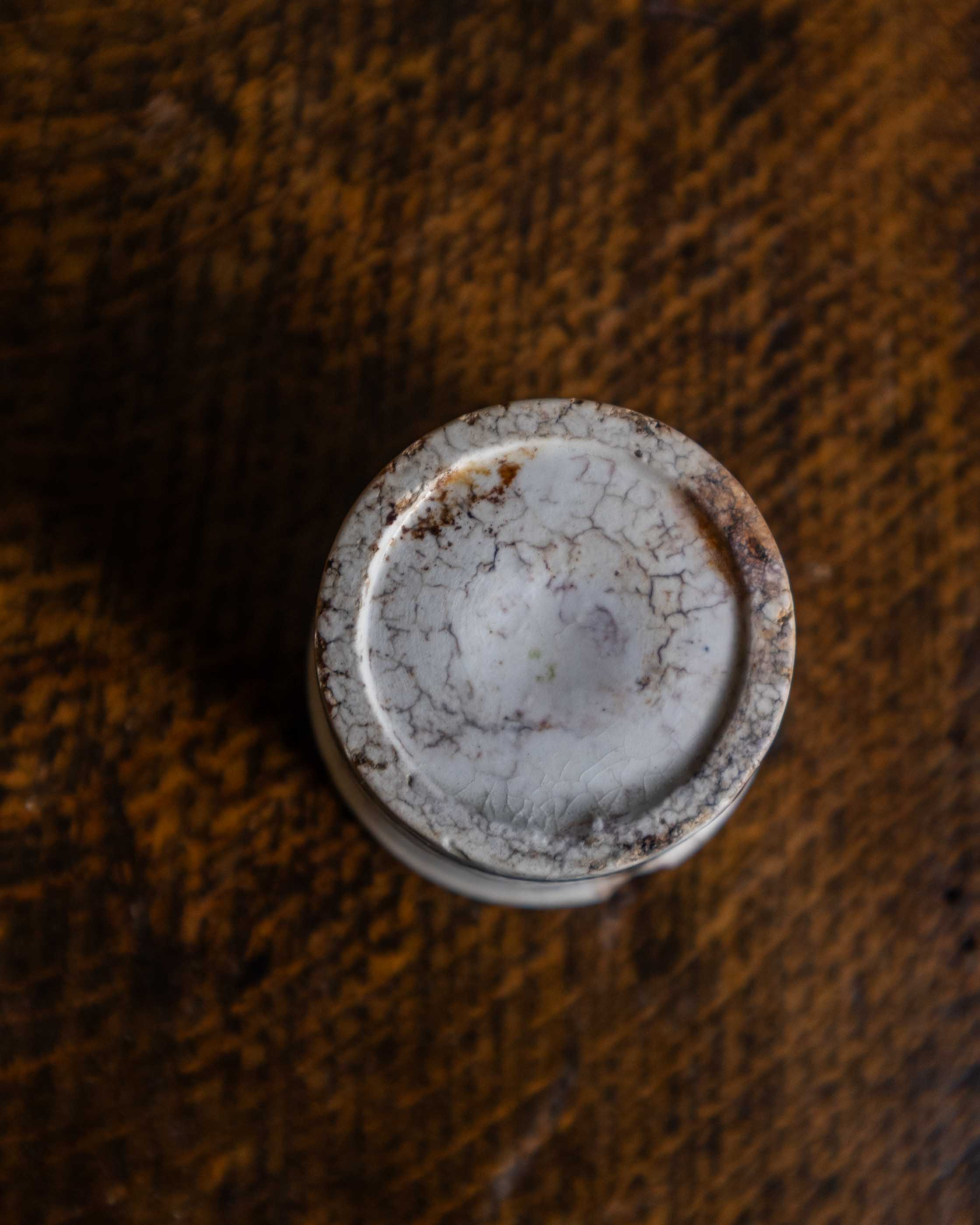 White ceramic pot on a textured brown surface
