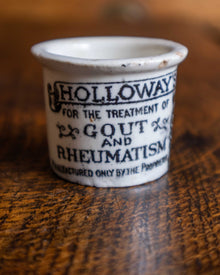 Ceramic pot with text on a wooden surface