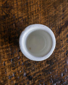 White ceramic pot on a textured brown surface