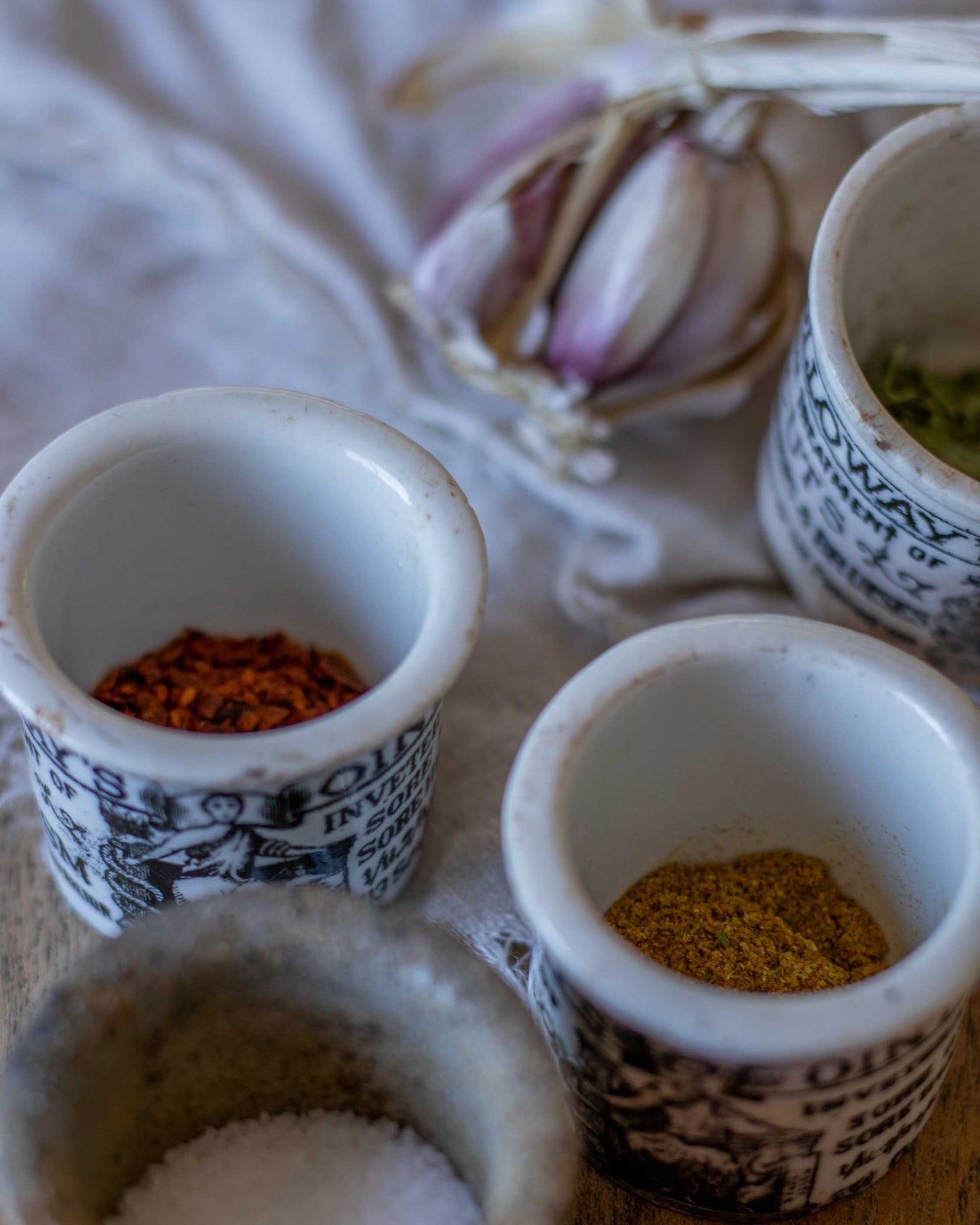 Small ceramic pots with spices on a textured surface