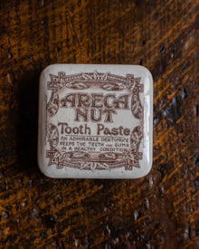 Areca Nut Tooth Paste lid on a wooden surface