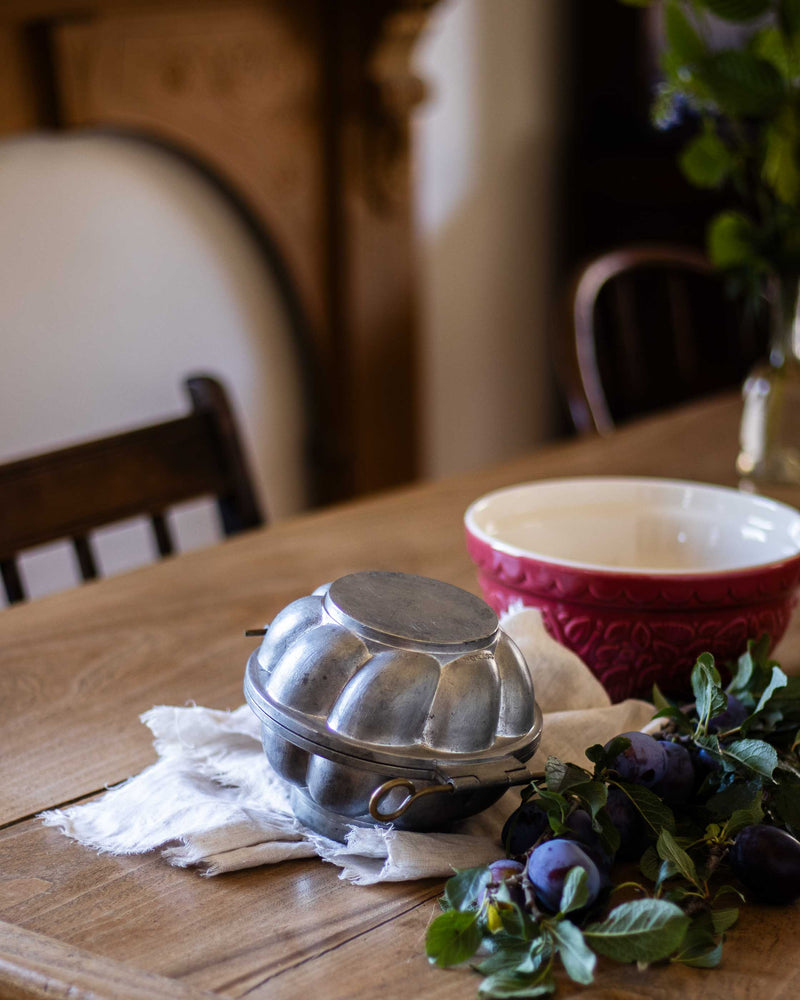 Pewter mould on a wooden table with a blurred background