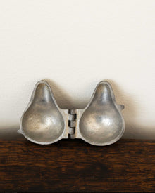 Pewter mould on a wooden surface with a white background