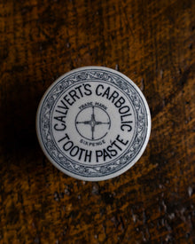Calvert's Carbolic Tooth Paste pot on a wooden surface