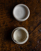 Two white ceramic bowls on a textured brown surface
