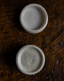 Two white ceramic bowls on a textured brown surface