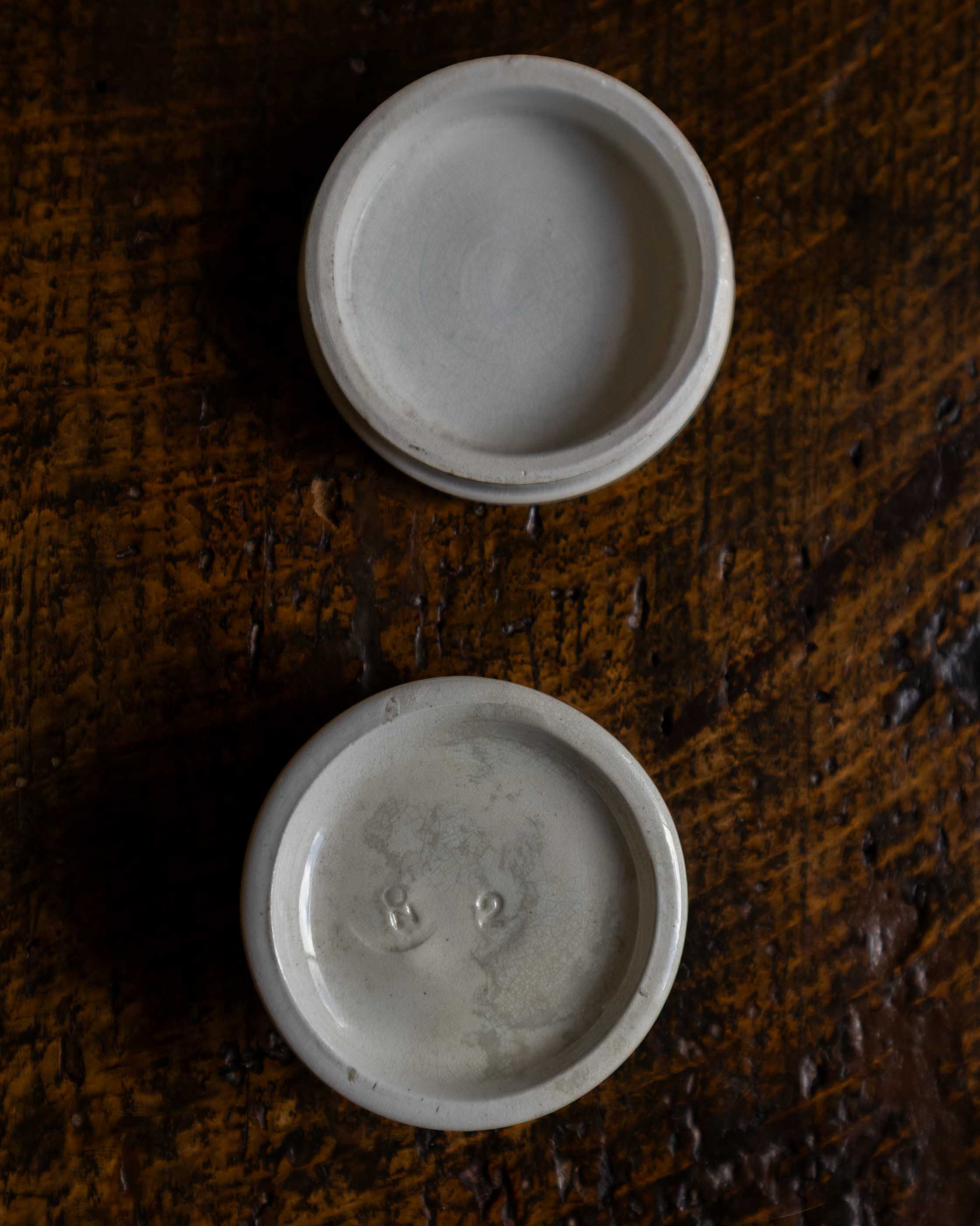 Two white ceramic bowls on a textured brown surface