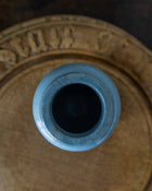 Close-up of a blue ceramic jar with a textured surface on a brown background