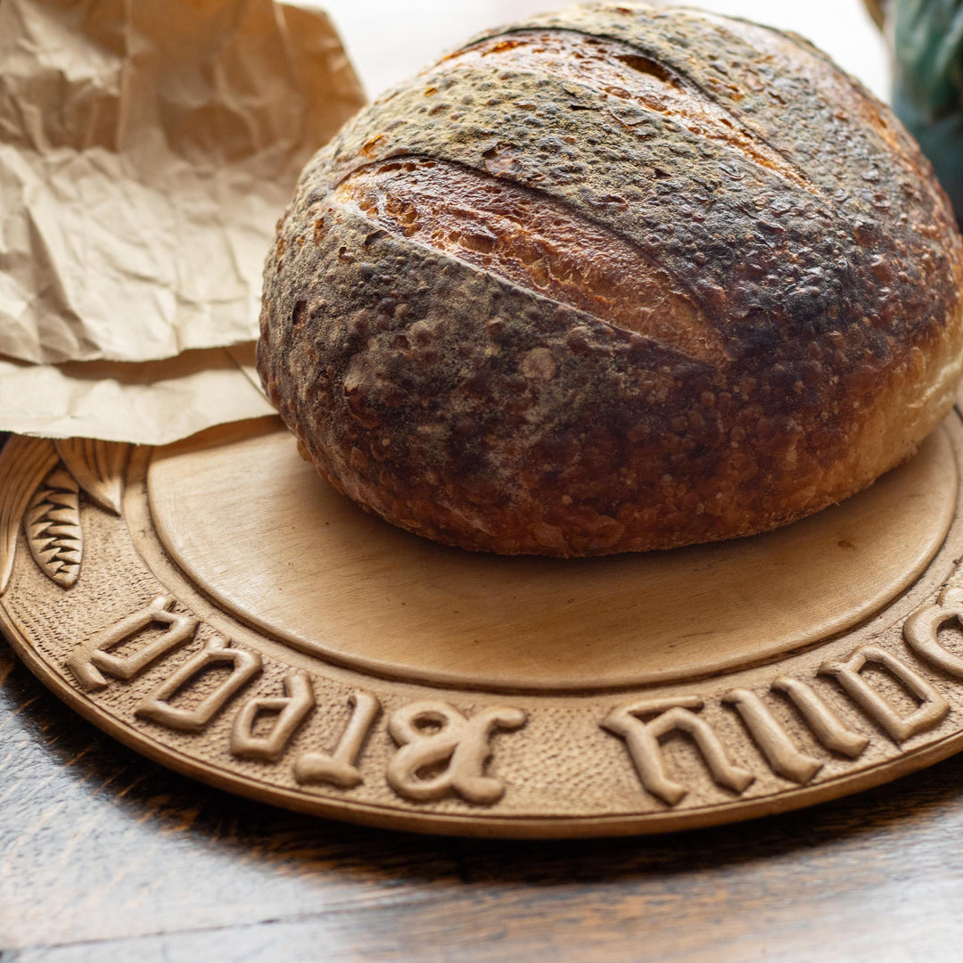 Loaf of bread on a decorative wooden breadboard 