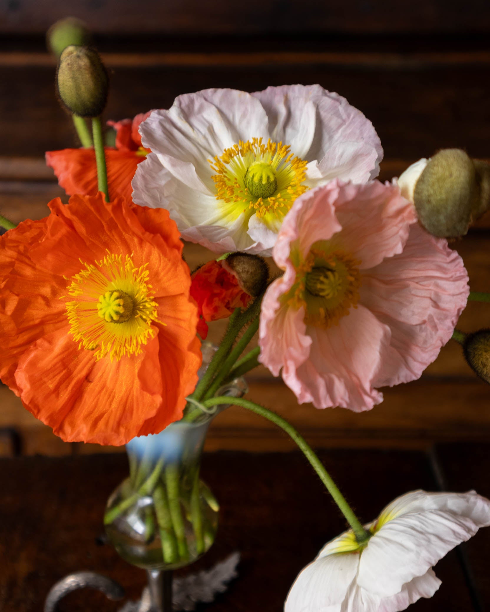 Vase with colorful flowers on a wooden surface