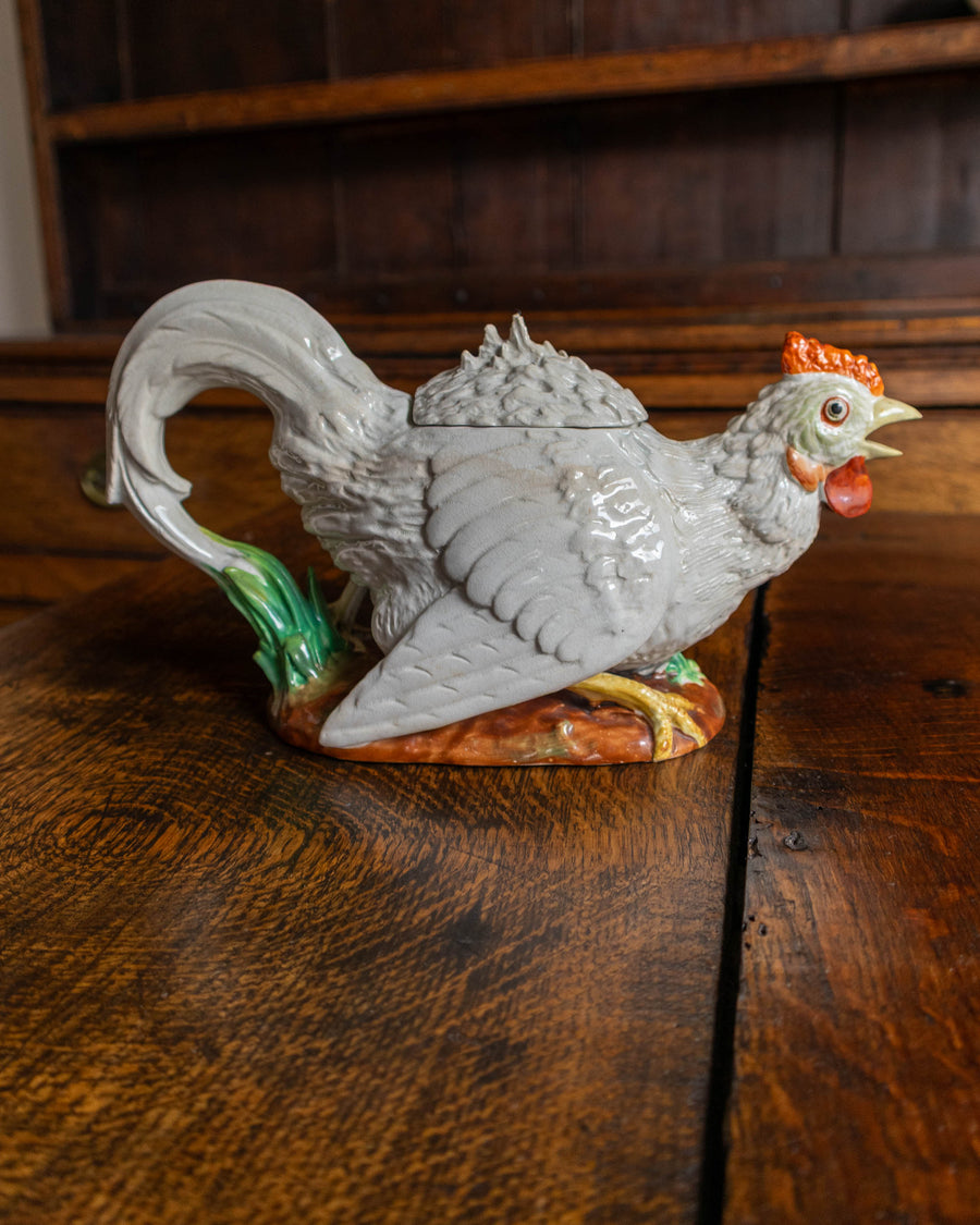Decorative ceramic rooster teapot on a wooden surface