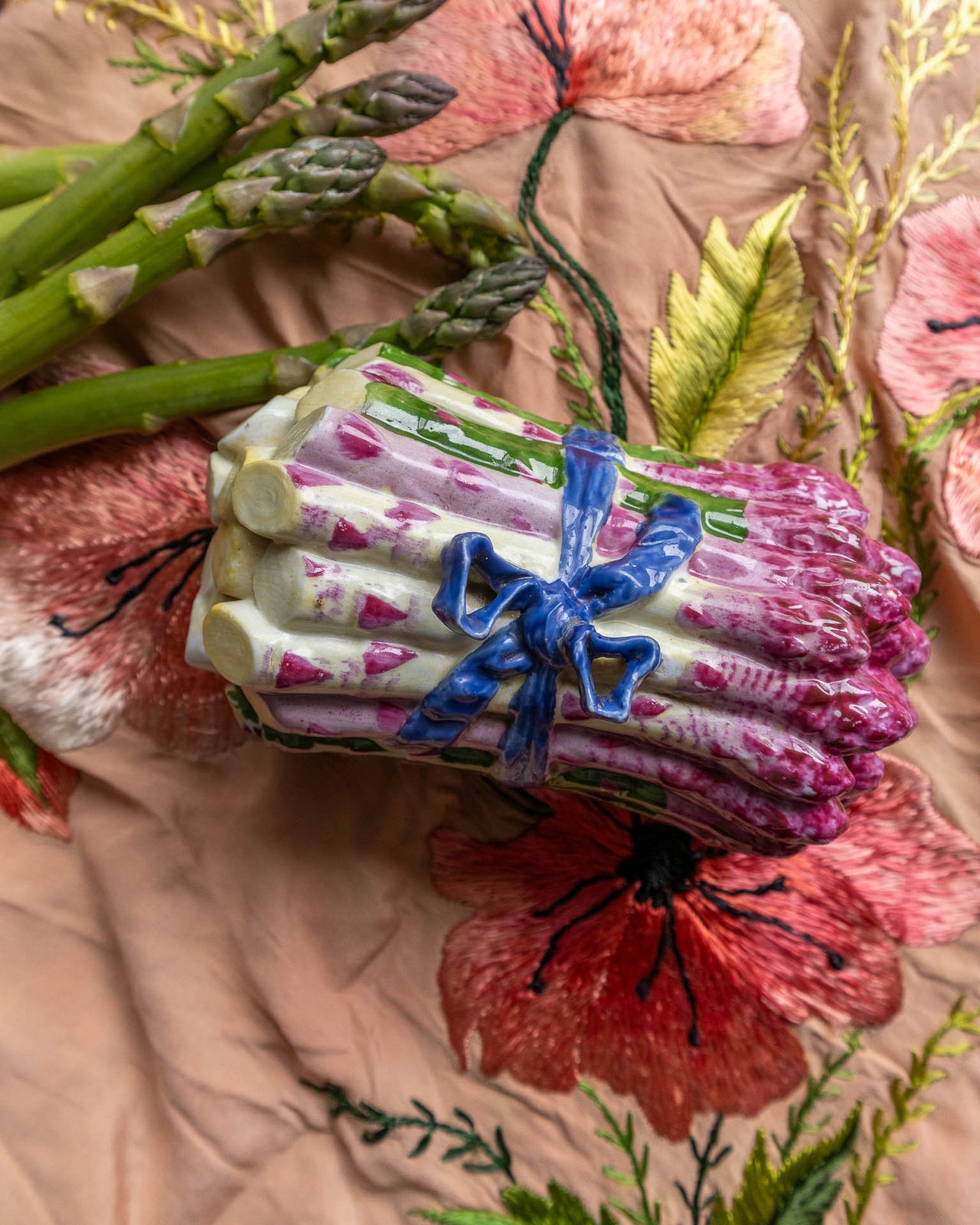 Porcelain asparagus box with a blue ribbon on a floral background
