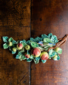 Decorative ceramic apple branch on a wooden surface