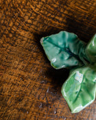 Green ceramic leaf on a wooden surface