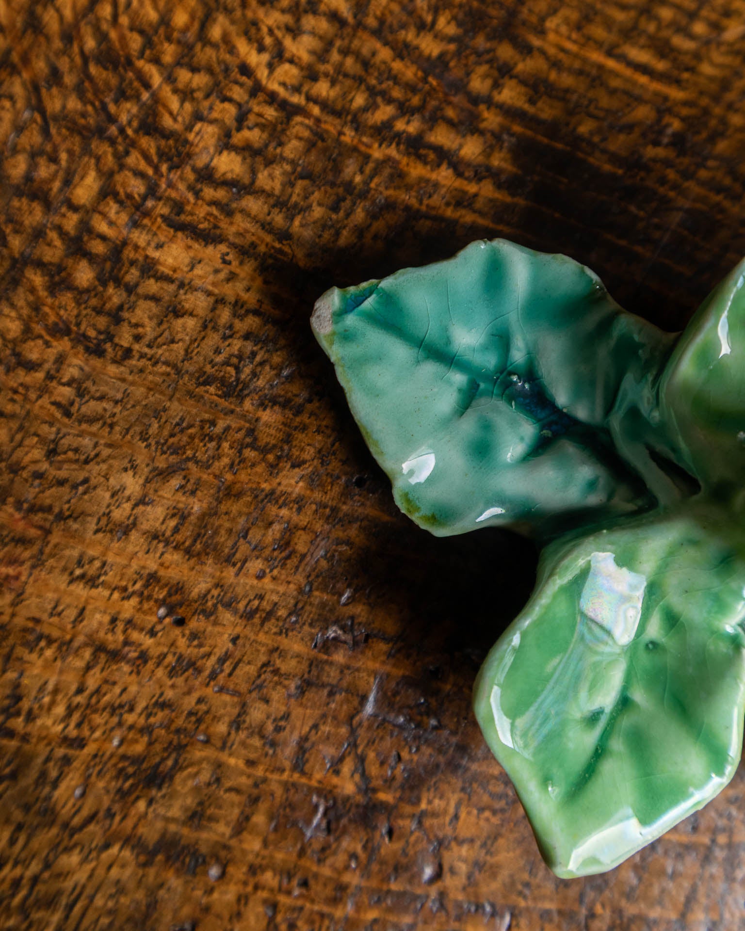 Green ceramic leaf on a wooden surface
