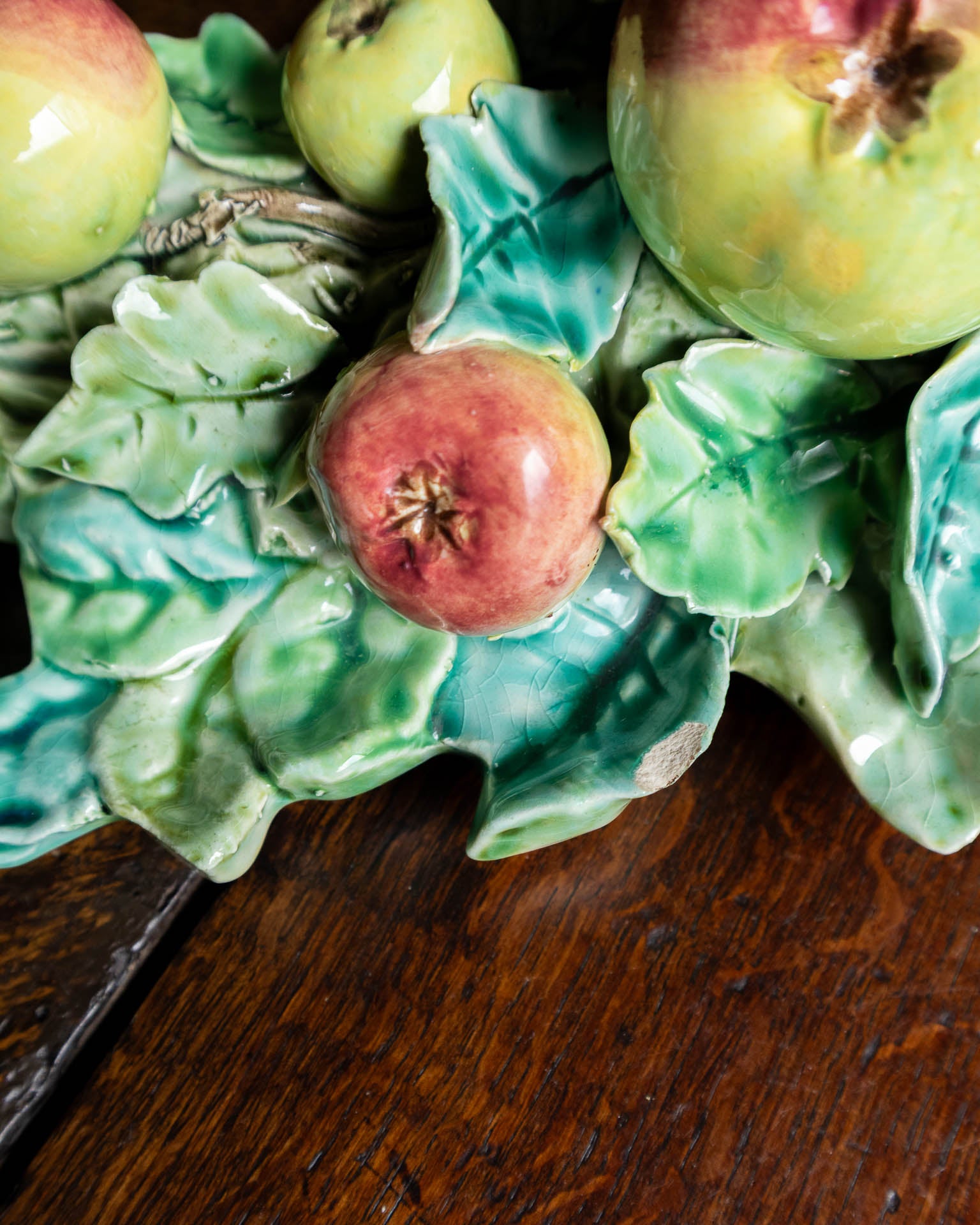 Decorative ceramic with apples and leaves on a wooden surface