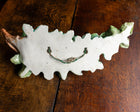 Decorative ceramic leaf-shaped object on a wooden surface