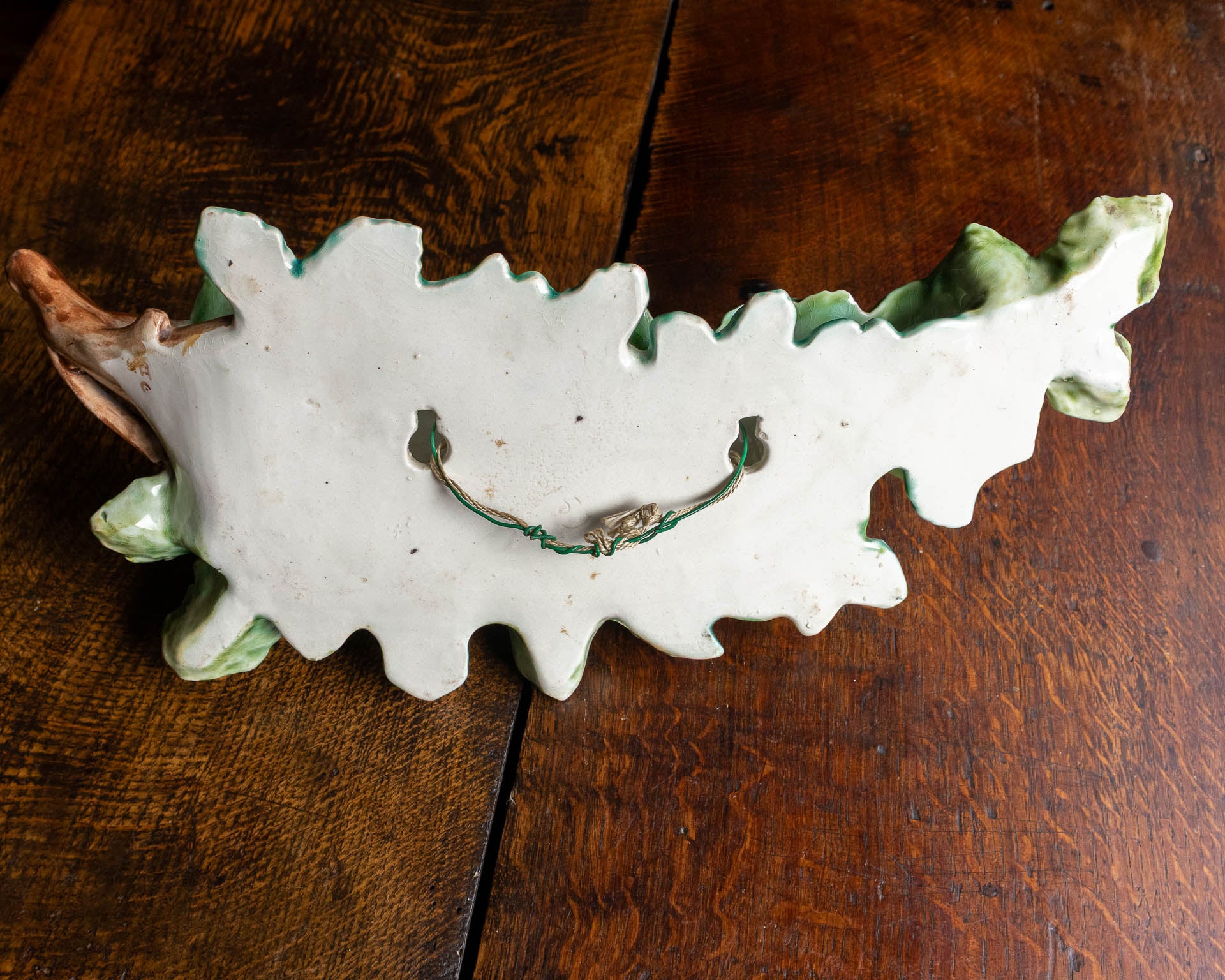 Decorative ceramic leaf-shaped object on a wooden surface