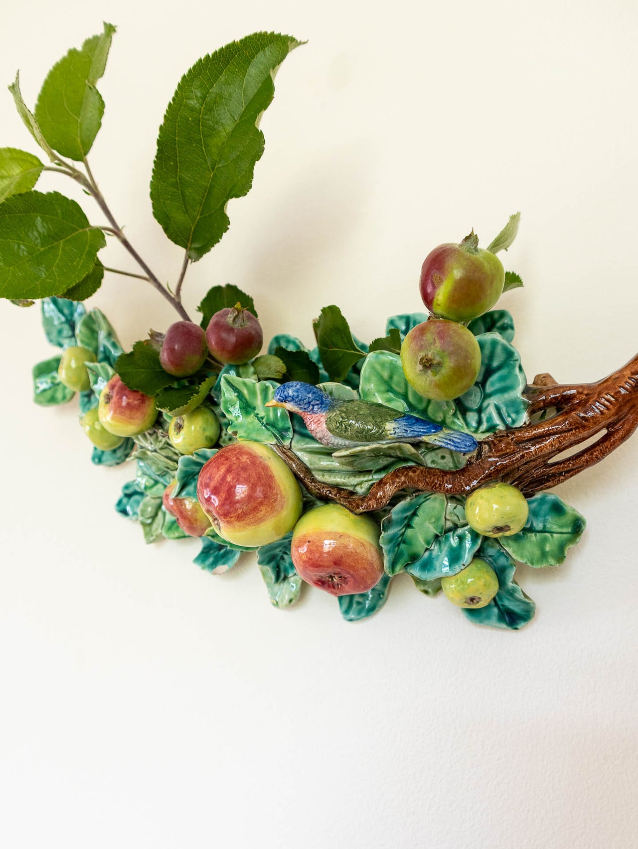 Decorative majolica wall pocket with fruits and leaves on a white background