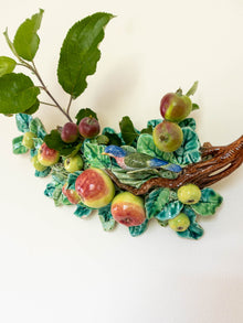 Decorative majolica wall pocket with fruits and leaves on a white background