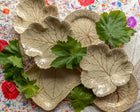 Decorative leaf-shaped Wedgwood plates with green leaves and flowers on a patterned background