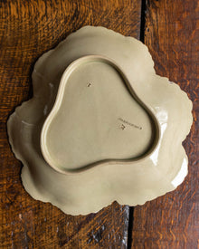 Ceramic Wedgwood dish with scalloped edge on a wooden surface