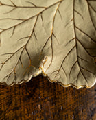 Close-up of a leaf-shaped ceramic Wedgwood plate on a wooden surface
