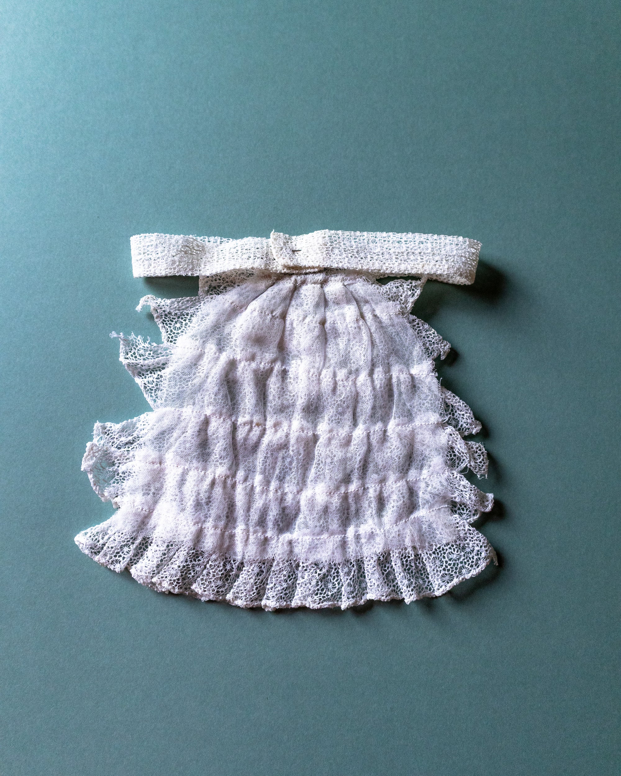 Lace jabot with a bow on a teal background