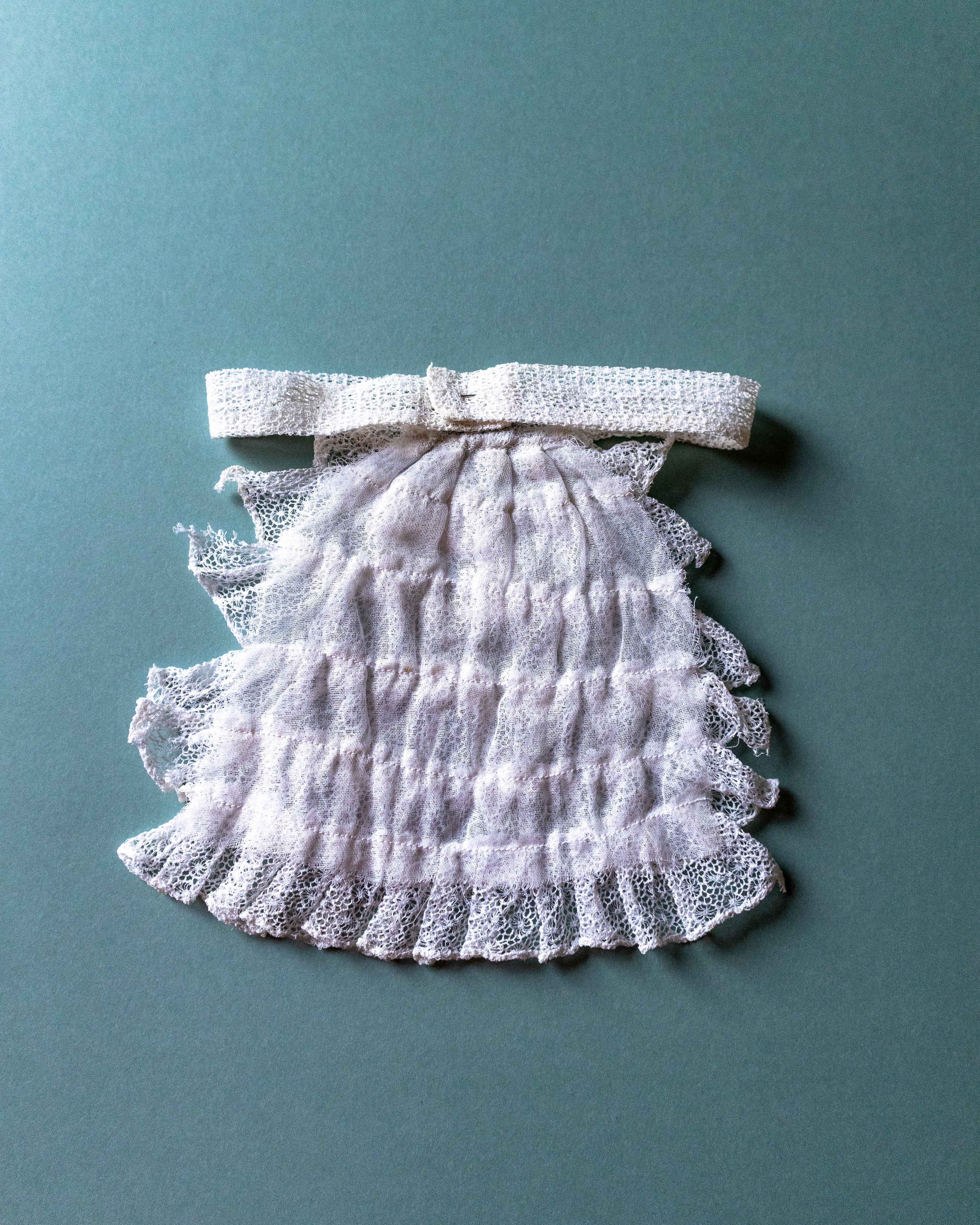 Lace jabot with a bow on a teal background